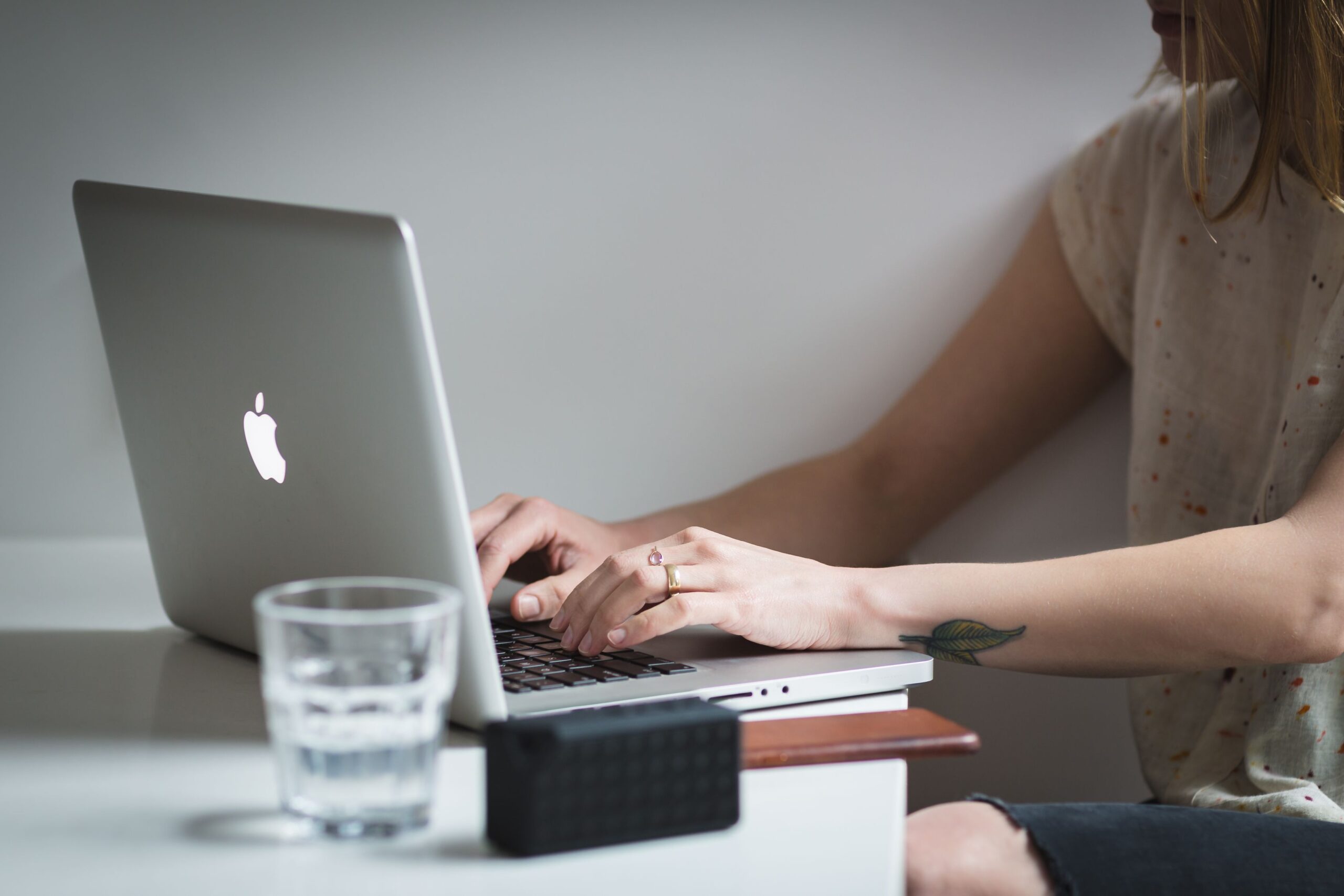 Blogger typing on a laptop at a desk while creating content with AI writing tools