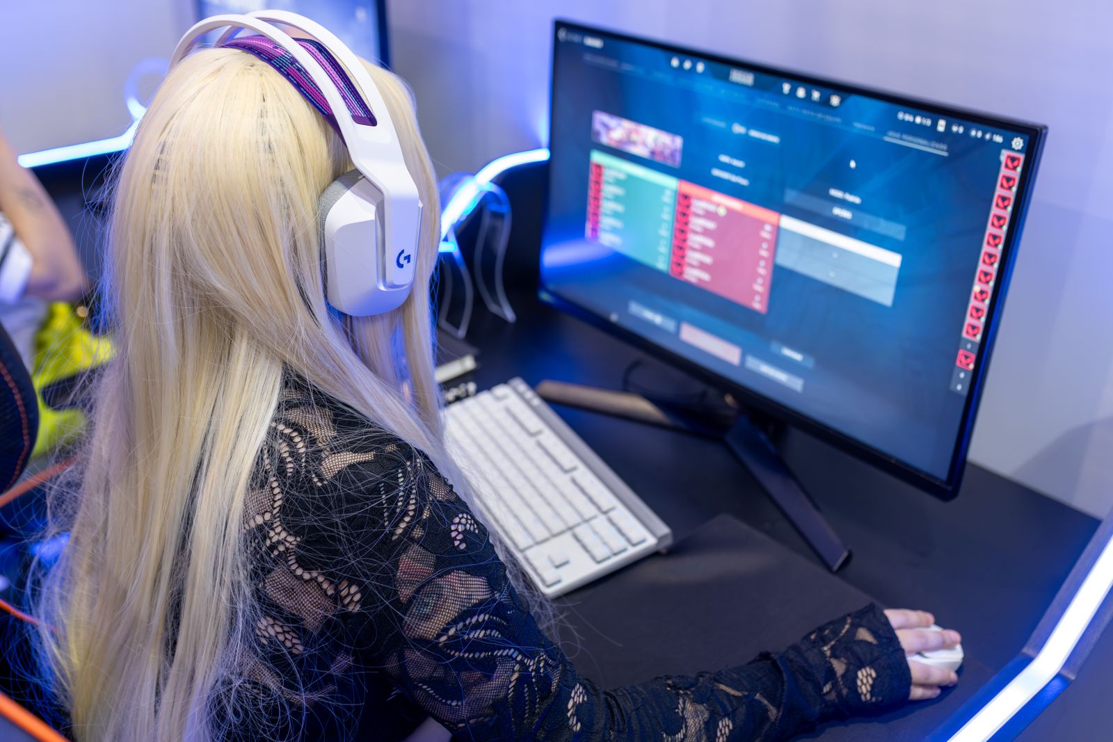 A gamer wearing headphones playing at a high-tech PC gaming setup