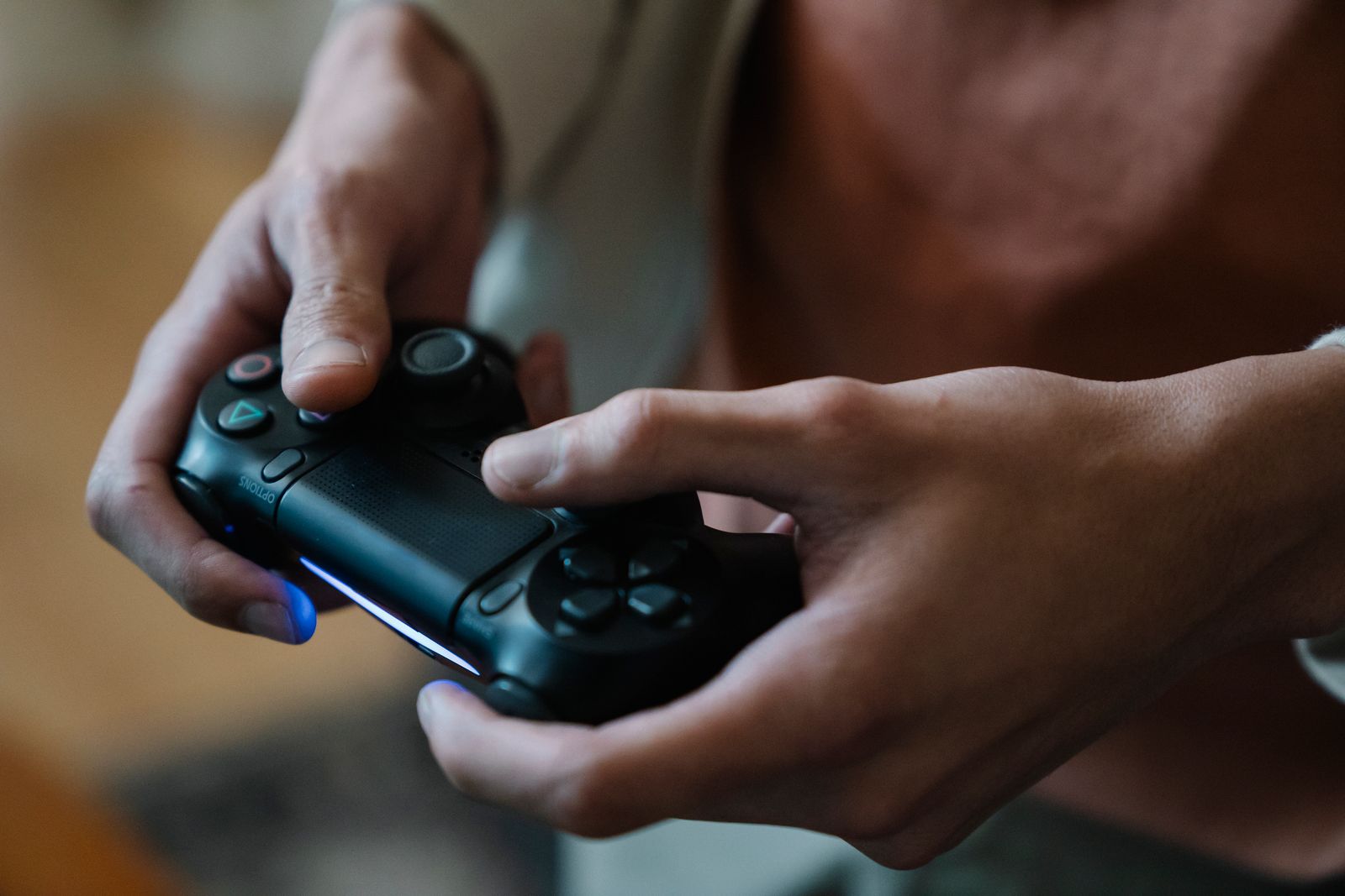 Gamer holding a game controller while playing a video game at home