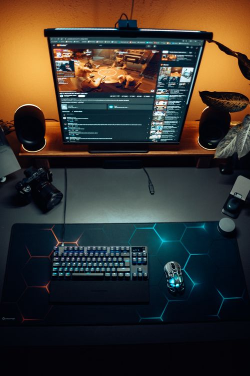 Compact gaming desk setup with RGB keyboard in a small room