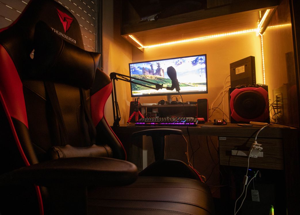 Dimly lit small-room gaming corner with desktop setup