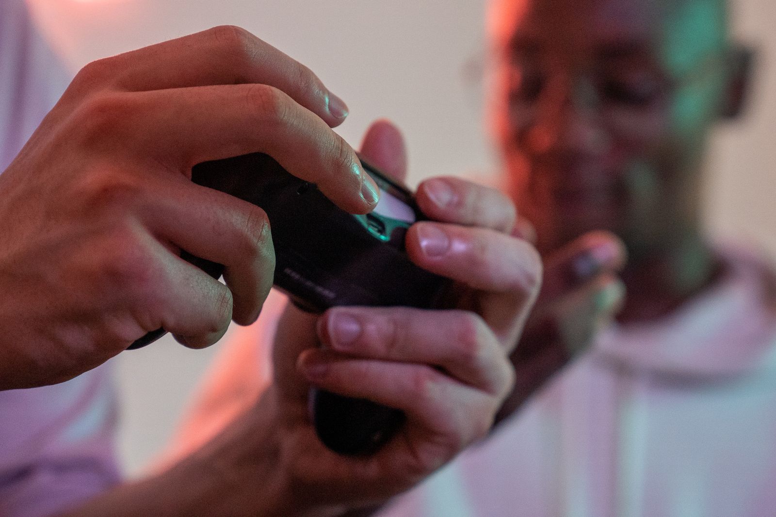 Two gamers intensely playing a video game together with a controller
